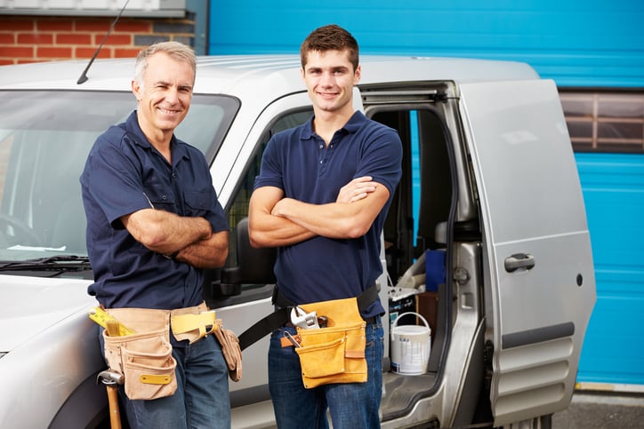 Workers In Family Business Standing Next To Van Smiling At Camera Workers In Family Business Standing Next To Van Smiling At Camera